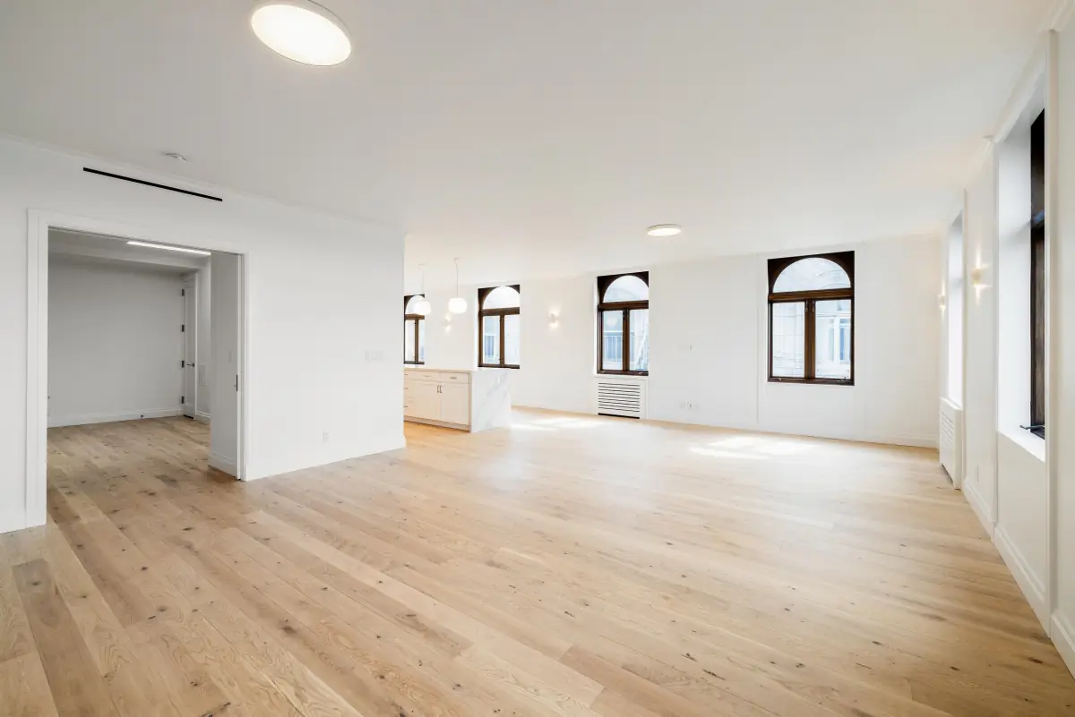 Renovated living room with oak floors and arched windows